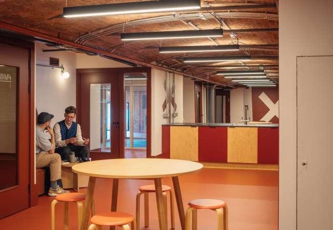 kitchen area being used for a meeting by 2 people