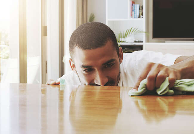 Man wiping table meticulously