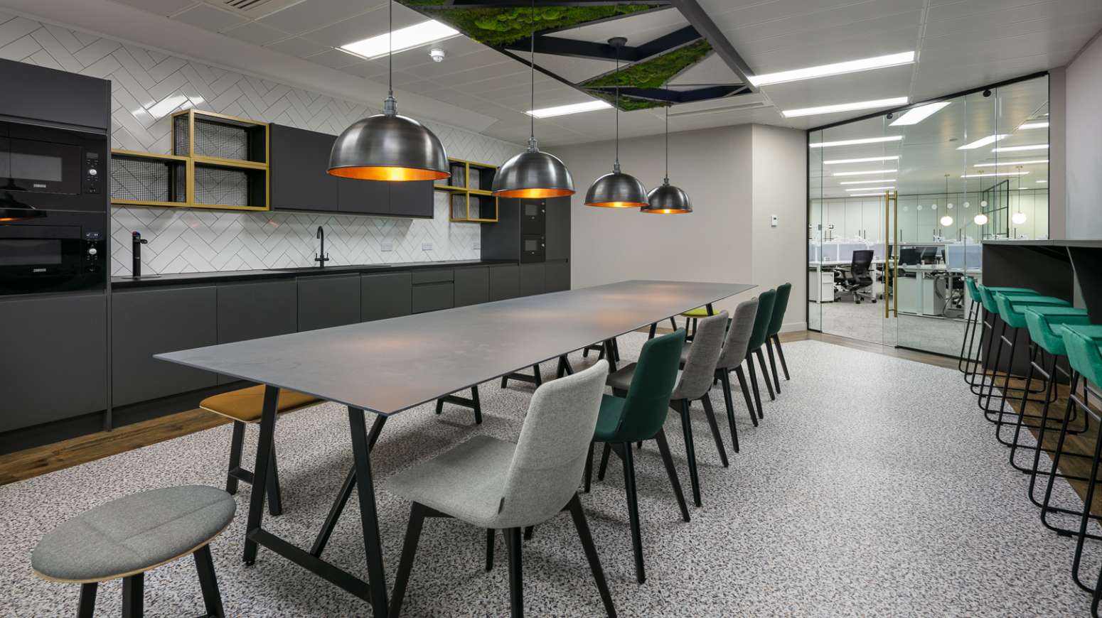 kitchen break out space with tables and chairs central location and pendent lighting