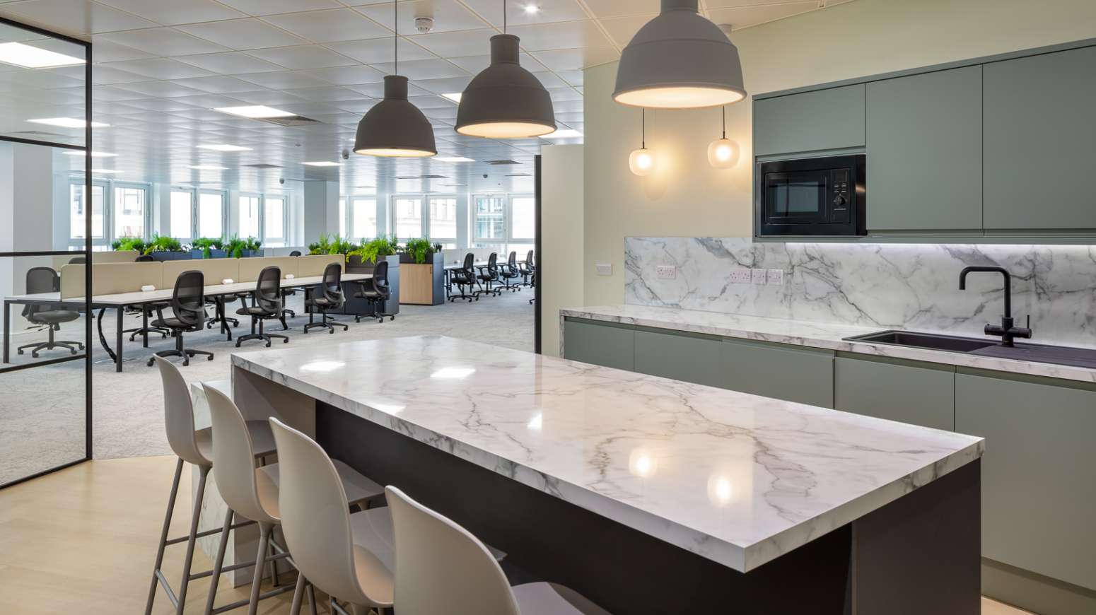 kitchen space looking out to open plan office with critall glass