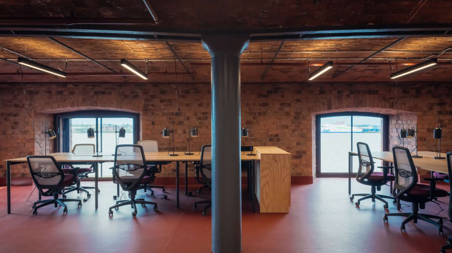 open plan office showing desks and exposed brickwork including iron columns