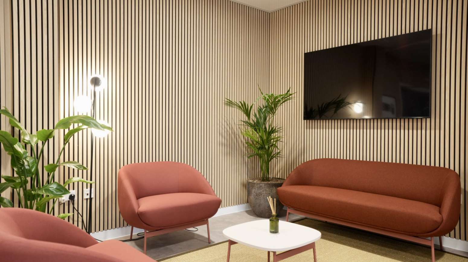 reception seating with TV and wooden slatted wall and new flooring