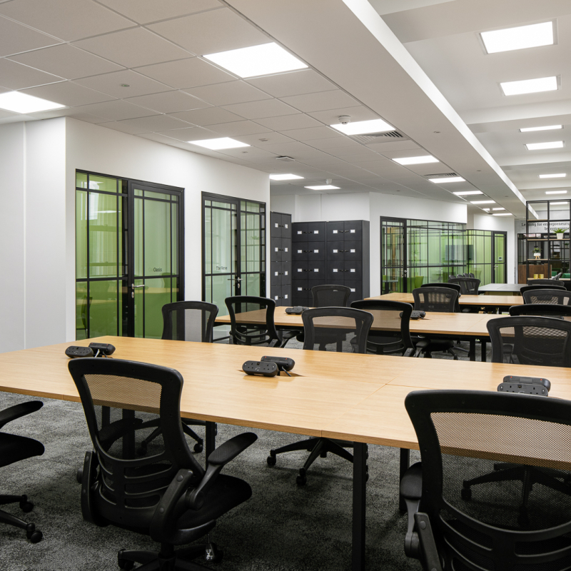 open plan desking with meeting rooms in background with VC